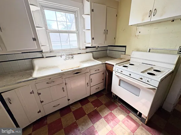 a kitchen with a stove sink and cabinets