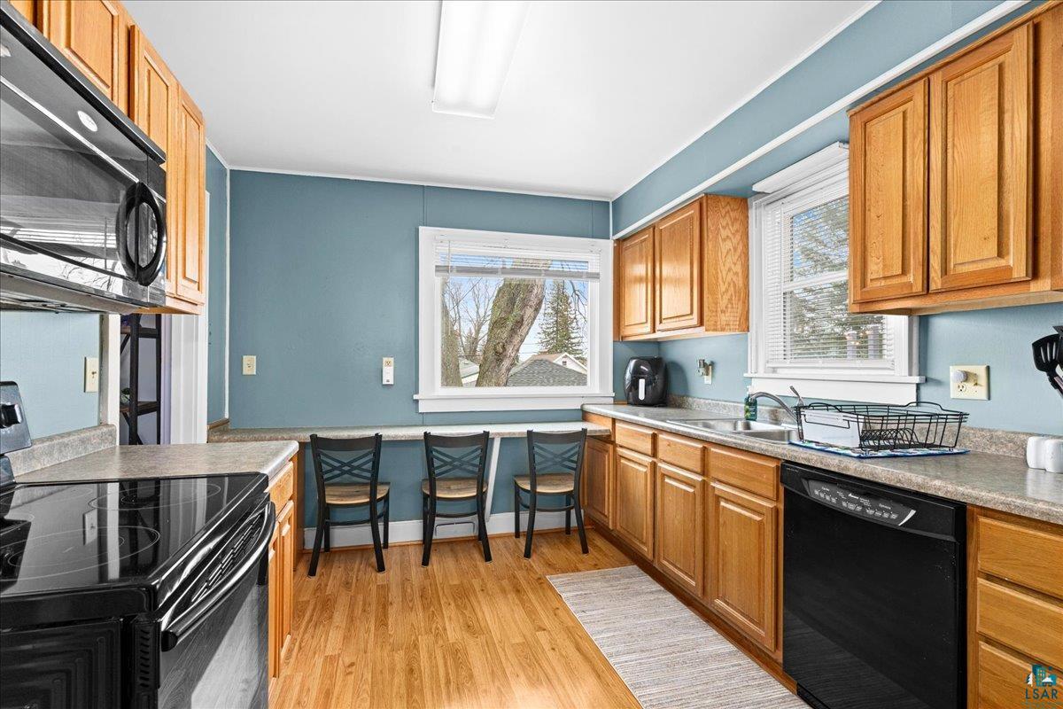 4316 West 6th Street Duluth, MN 55807 - Photo 3 of 39 Kitchen with black appliances, light wood-style floors, wood finish cabinetry, and light countertops