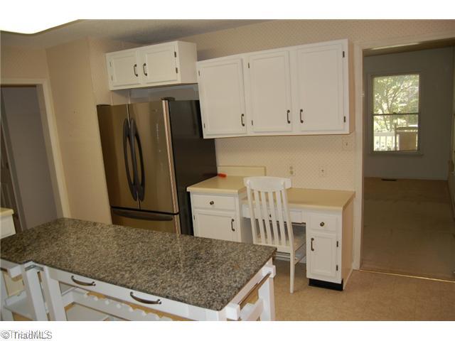 7600 Wallingford Road Greensboro, NC 27409 - Photo 9 of 14 Kitchen. This view of the kitchen shows cabinets and built-in desk