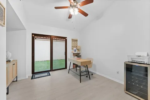 a workspace with wooden floor and a chandelier fan