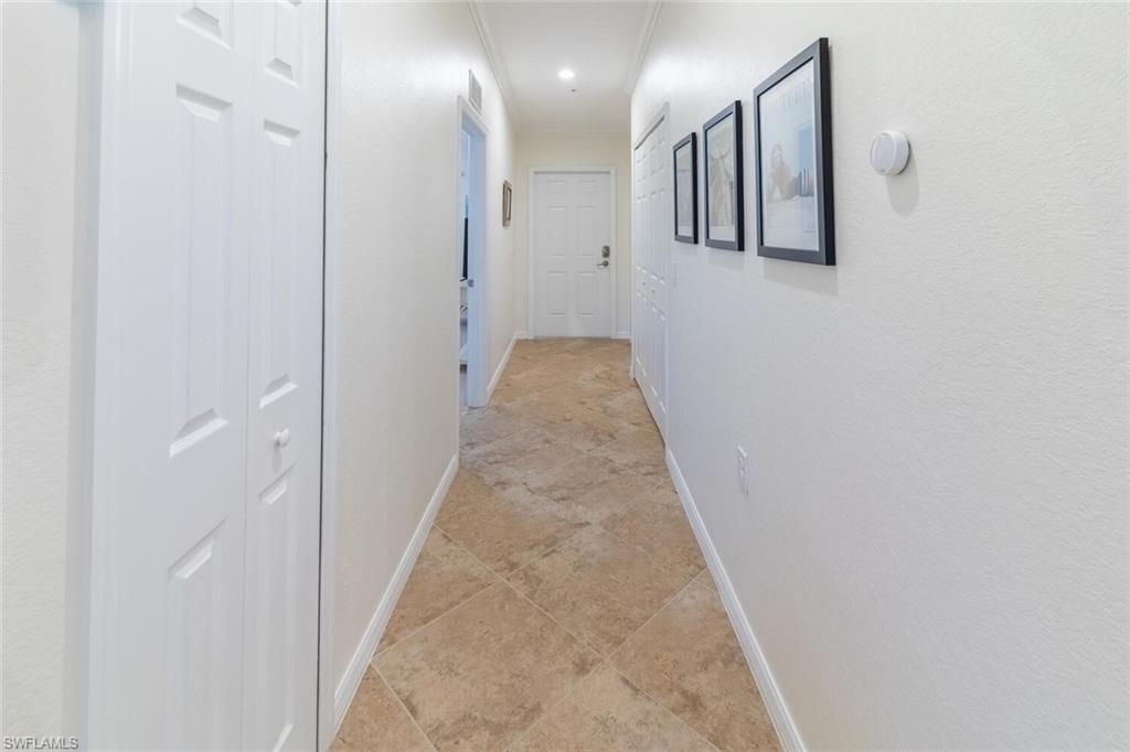 9828 Venezia Circle, Unit 1124 Naples, FL 34113 - Photo 16 of 50 a view of a hallway with wooden floor