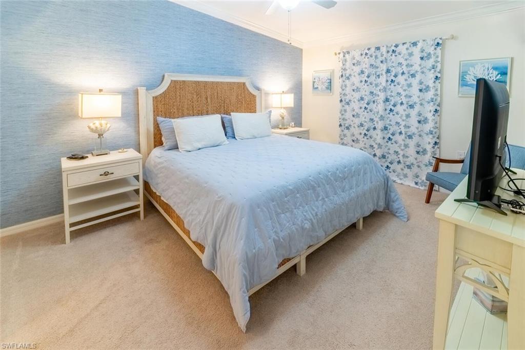 9828 Venezia Circle, Unit 1124 Naples, FL 34113 - Photo 17 of 50 a bedroom with a bed and a flat tv screen on dresser