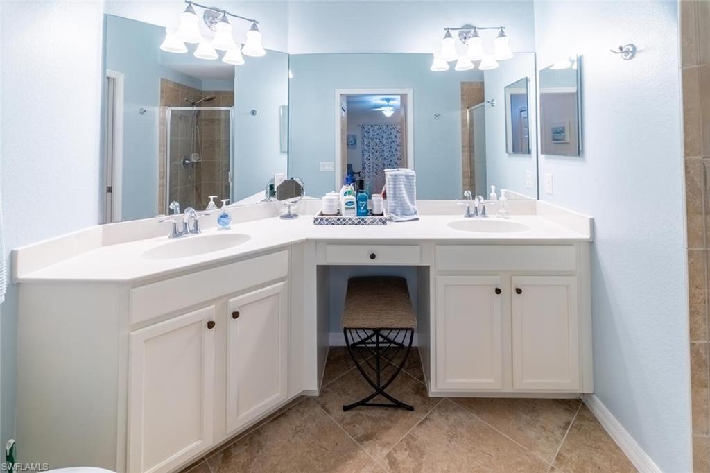 9828 Venezia Circle, Unit 1124 Naples, FL 34113 - Photo 20 of 50 a en suite bathroom with a sink and a mirror