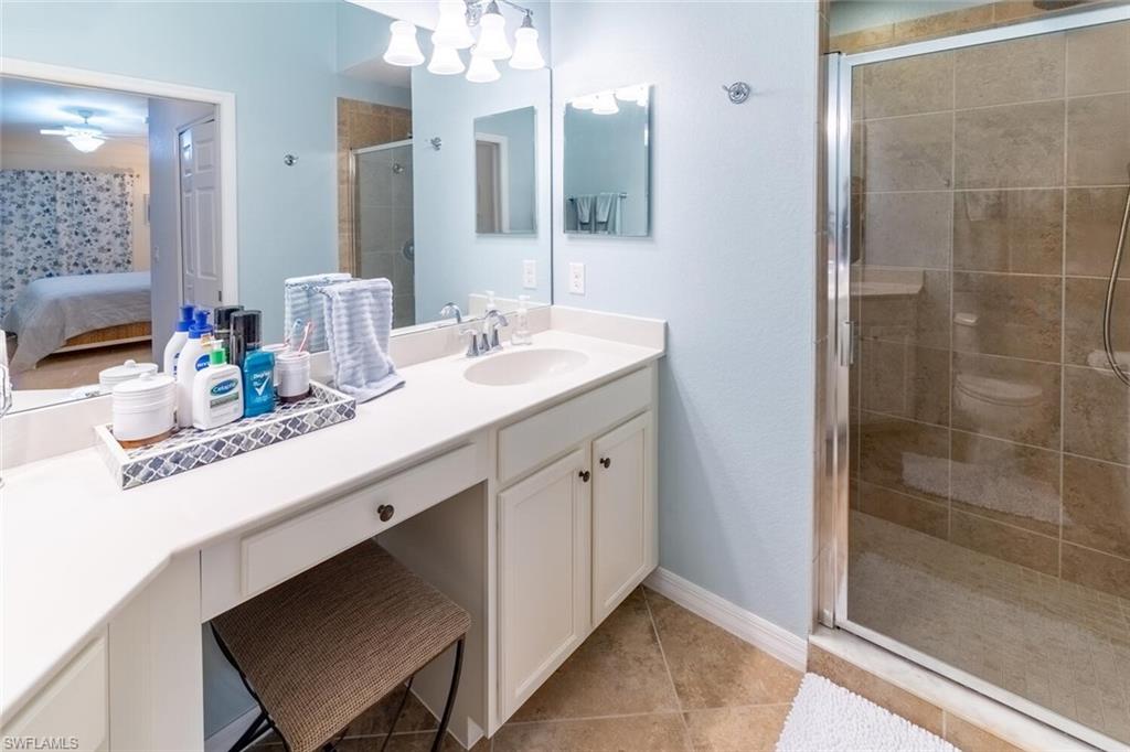 9828 Venezia Circle, Unit 1124 Naples, FL 34113 - Photo 21 of 50 a bathroom with a sink double vanity and a mirror