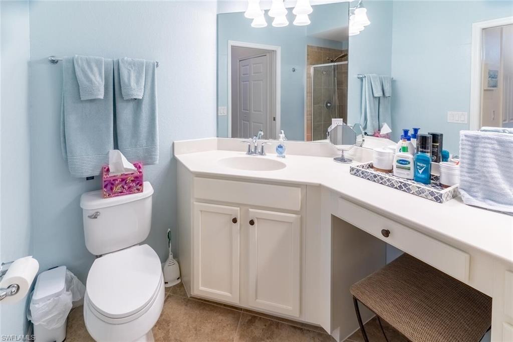 9828 Venezia Circle, Unit 1124 Naples, FL 34113 - Photo 22 of 50 a bathroom with a toilet sink and mirror