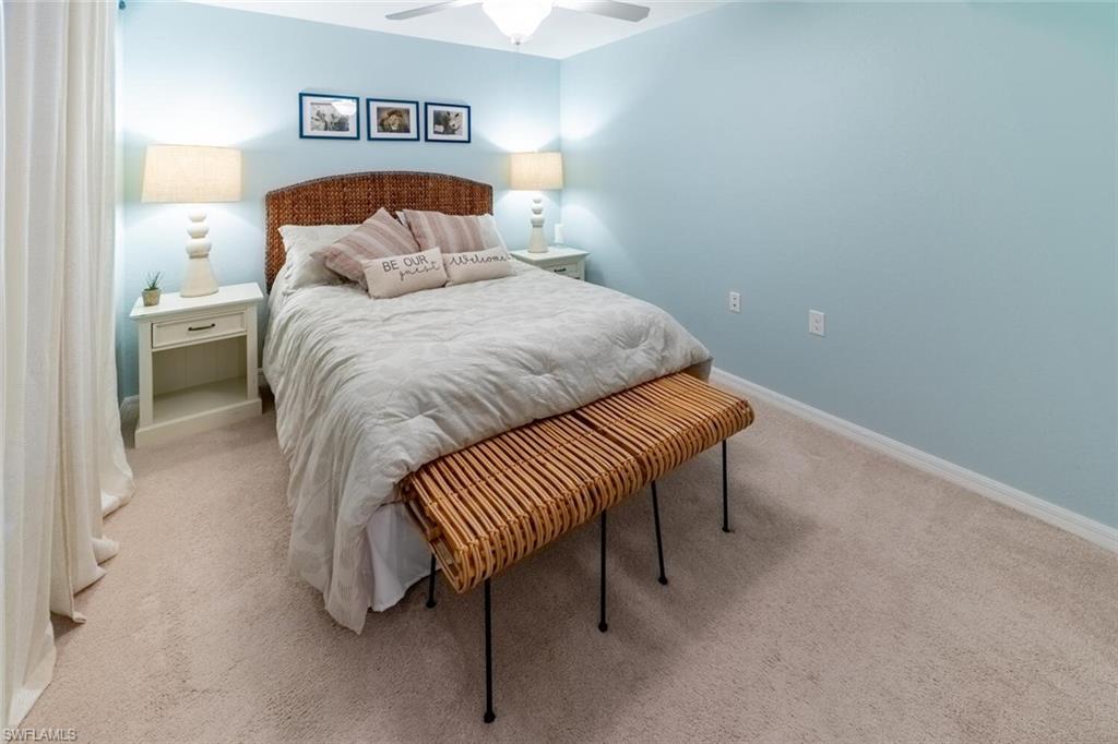 9828 Venezia Circle, Unit 1124 Naples, FL 34113 - Photo 23 of 50 a bedroom with a bed and a lamp