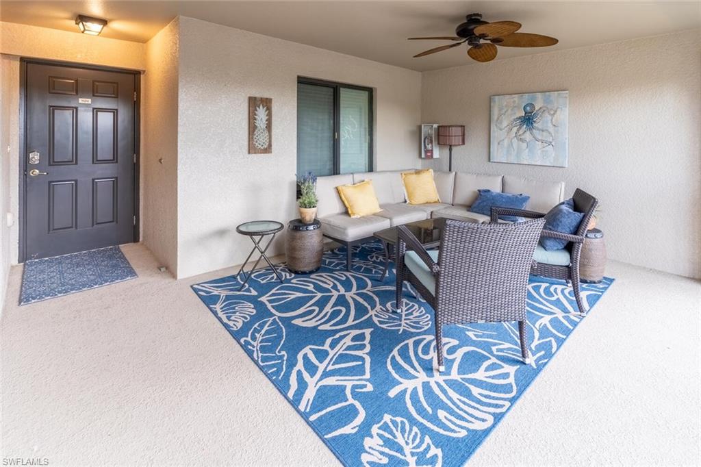 9828 Venezia Circle, Unit 1124 Naples, FL 34113 - Photo 4 of 50 a living room with furniture and wooden floor