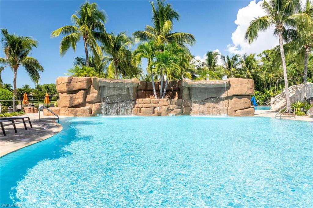 9828 Venezia Circle, Unit 1124 Naples, FL 34113 - Photo 41 of 50 a backyard of a house with table and chairs plants and swimming pool