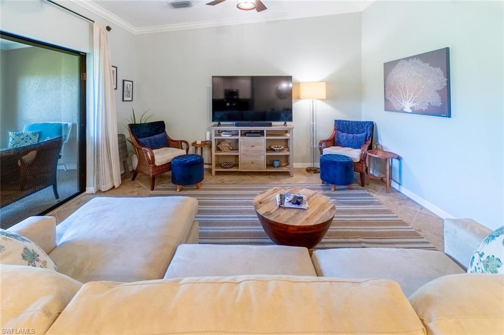 9828 Venezia Circle, Unit 1124 Naples, FL 34113 - Photo 7 of 50 a living room with furniture and a flat screen tv