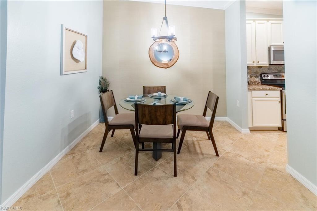 9828 Venezia Circle, Unit 1124 Naples, FL 34113 - Photo 9 of 50 a dining room with furniture and window