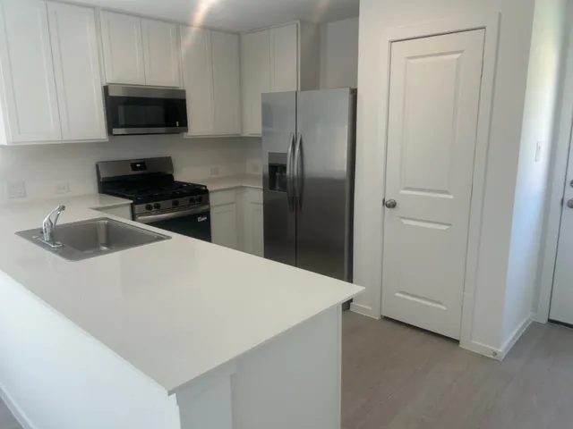 a kitchen with a refrigerator and a stove top oven