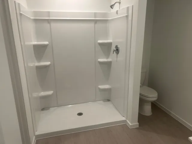 a bathroom with a toilet and a shower