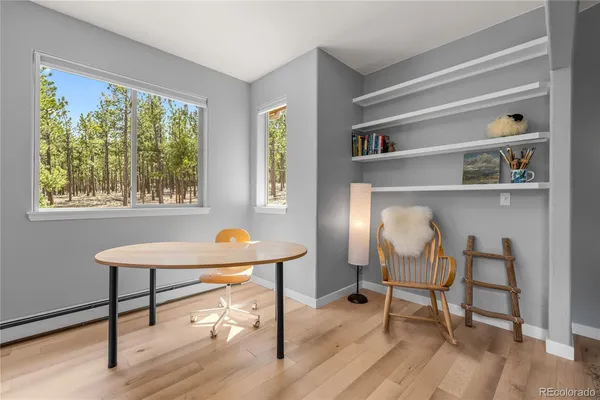 a view of a workspace with furniture and a window