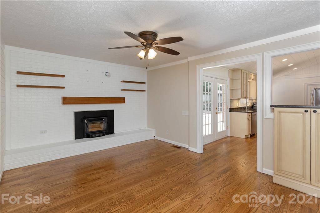 160 Cold Springs Road Hendersonville, NC 28792 - Photo 6 of 26 a view of an empty room with a fireplace and a ceiling fan