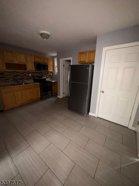 a kitchen with stainless steel appliances a refrigerator and a stove top oven