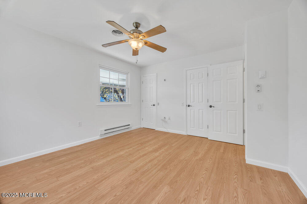 5B Spring Street, Unit B Whiting, NJ 08759 - Photo 21 of 39 a view of an empty room with chandelier fan and wooden floor