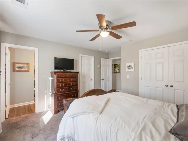 a bedroom with a bed and a flat tv screen on a dresser