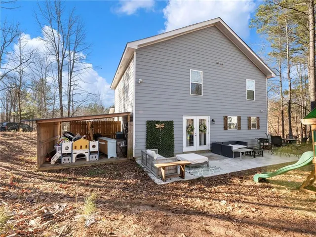 a view of a house with a yard siting area and fire pit