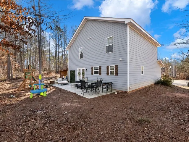 a view of a house with backyard and chairs