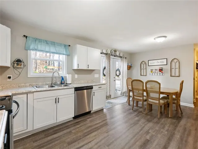 a kitchen with granite countertop cabinets dining table and stainless steel appliances