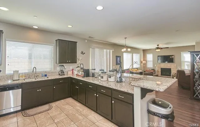 a large kitchen with a large counter top space a sink stainless steel appliances and cabinets
