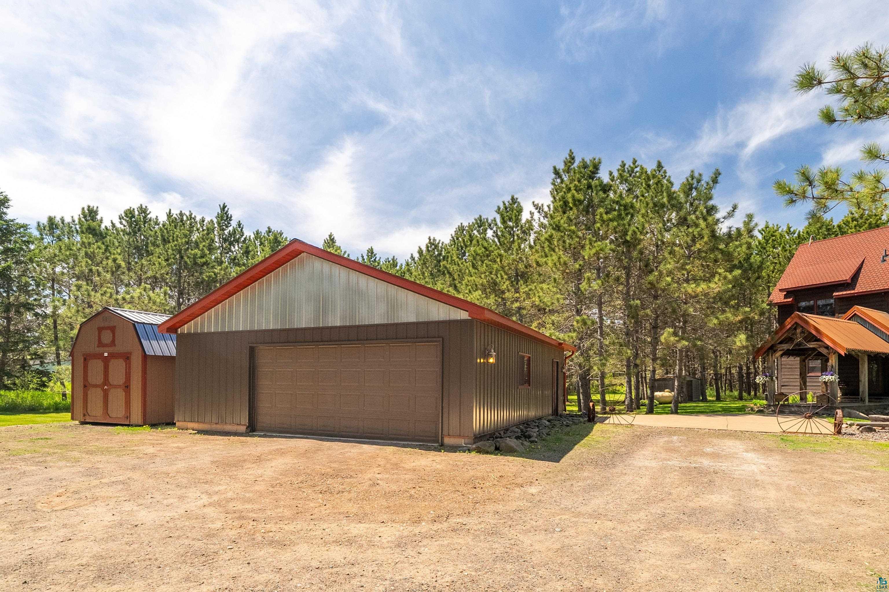 75 East Stark Road Esko, MN 55733 - Photo 70 of 87 Detached garage featuring a brown overhead door, brown siding, and a red metal roof