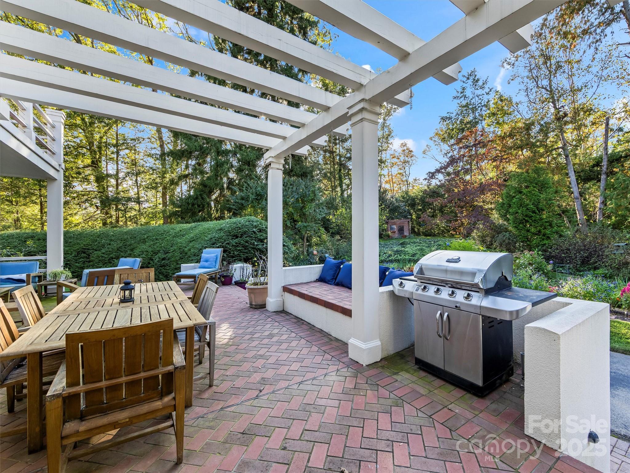 7 Park Road Asheville, NC 28803 - Photo 23 of 48 a view of a patio with table and chairs potted plants with floor to ceiling window and wooden fence