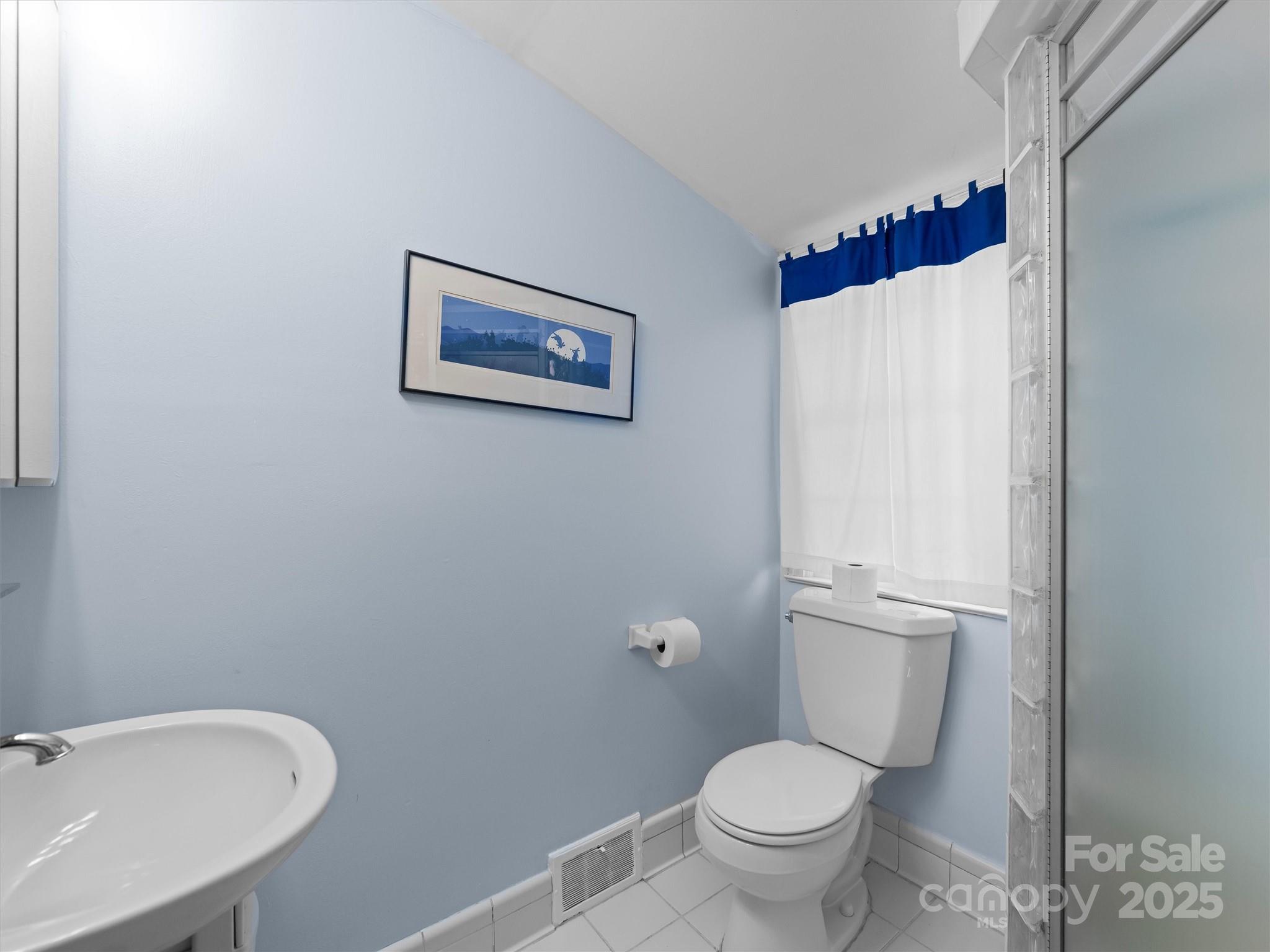 7 Park Road Asheville, NC 28803 - Photo 38 of 48 a white toilet sitting next to a bathroom sink