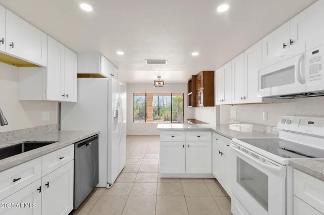 a kitchen with granite countertop cabinets stainless steel appliances and a window