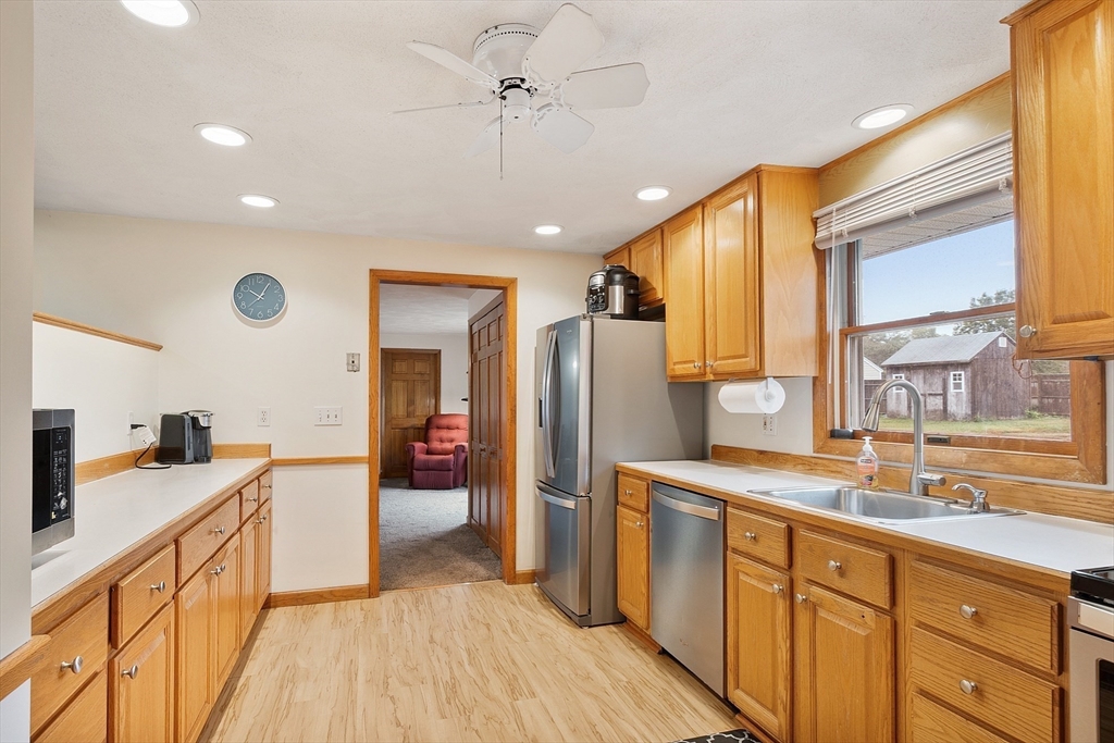 6 Colgate Street Danvers, MA 01923 - Photo 14 of 38 a large kitchen with stainless steel appliances granite countertop a refrigerator a sink dishwasher and a stove with wooden cabinets