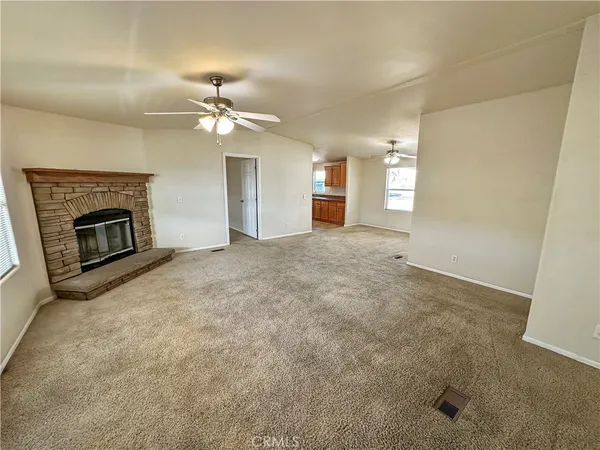 an empty room with windows and fireplace