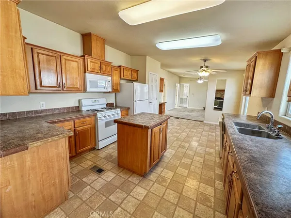 a large kitchen with kitchen island granite countertop a sink counter and cabinets