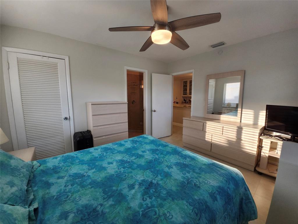 8777 Warwick Drive, Unit 265 Boca Raton, FL 33433 - Photo 19 of 31 a bedroom with a bed and a flat tv screen on dresser