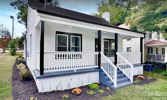 a view of a house with wooden deck and a floor to ceiling window