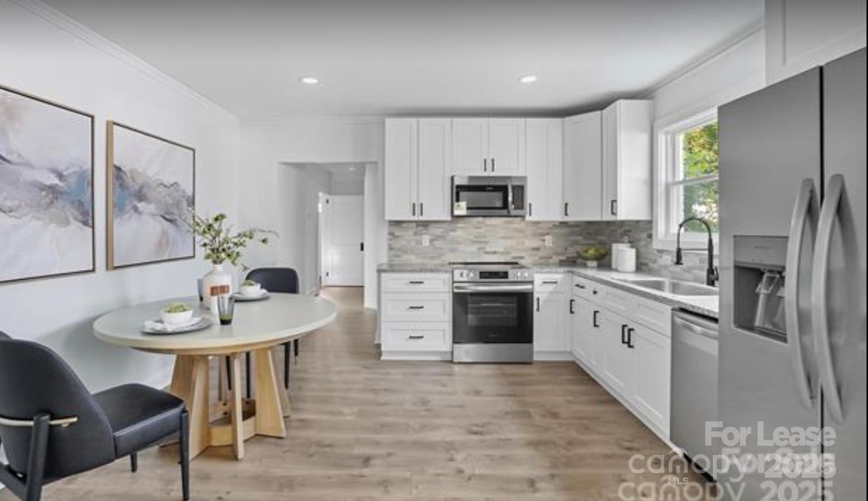 64 Brumley Avenue Northeast Concord, NC 28025 - Photo 5 of 19 a kitchen with stainless steel appliances a stove a sink a microwave a refrigerator and a table
