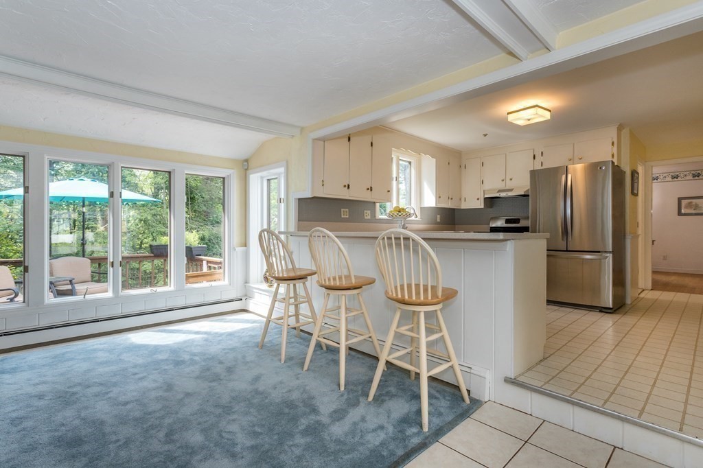 7 Lillian Road Canton, MA 02021 - Photo 8 of 27 a kitchen with stainless steel appliances granite countertop a stove top oven a refrigerator a table and chairs