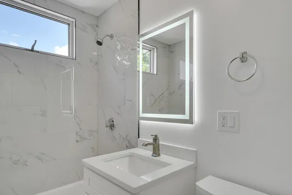 a bathroom with a sink toilet and shower