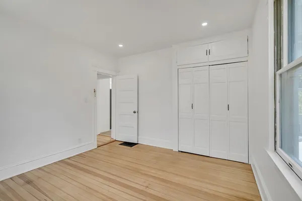 a view of empty room with wooden floor