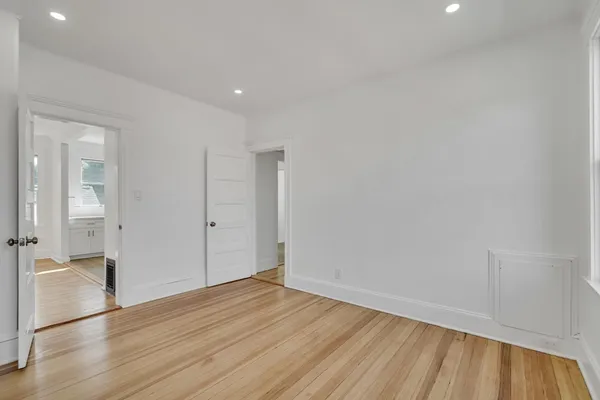 a view of empty room with wooden floor