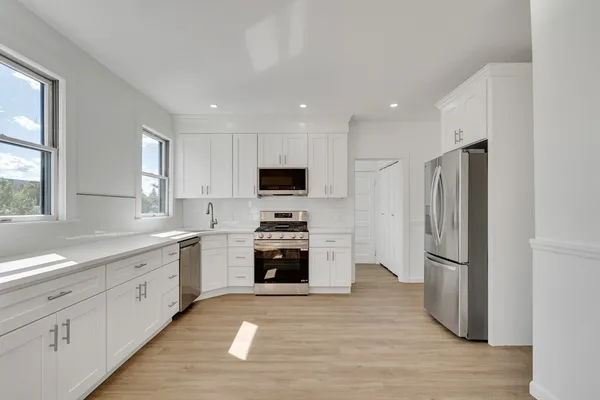 a kitchen with granite countertop a refrigerator oven a sink and dishwasher