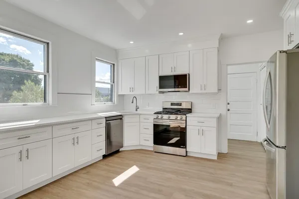 a kitchen with white cabinets and stainless steel appliances