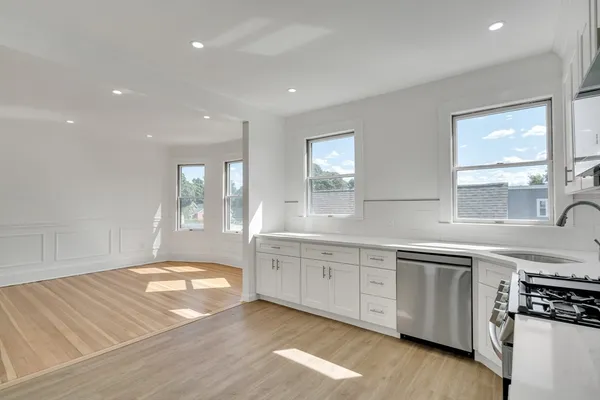 a large kitchen with stainless steel appliances granite countertop a sink and a stove