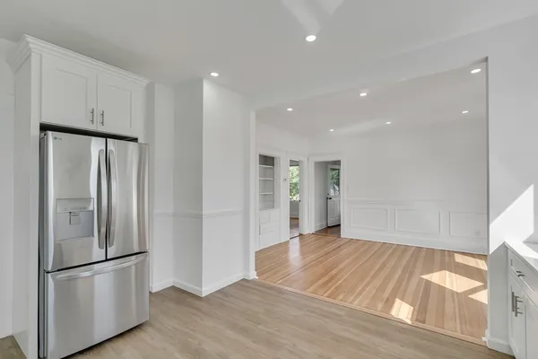 a view of a kitchen with a refrigerator and wooden floor