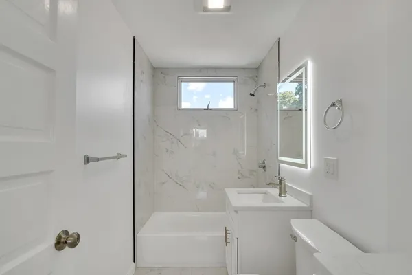 a bathroom with a sink a toilet and shower