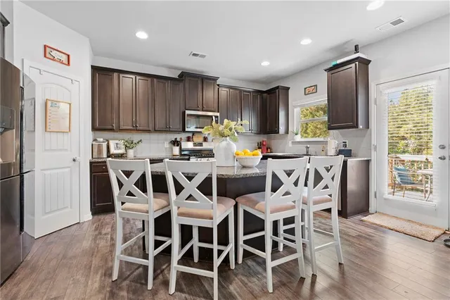 a kitchen with granite countertop stainless steel appliances wooden cabinets a sink and a stove