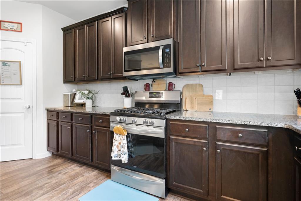 511 Autumn Echo Canton, GA 30114 - Photo 16 of 45 a kitchen with granite countertop wood cabinets stainless steel appliances and a sink