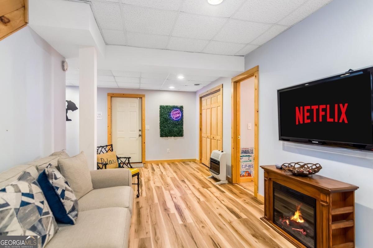 174 Seneca Way, Unit 116 Ellijay, GA 30540 - Photo 32 of 39 a living room with furniture a flat screen tv and a fireplace