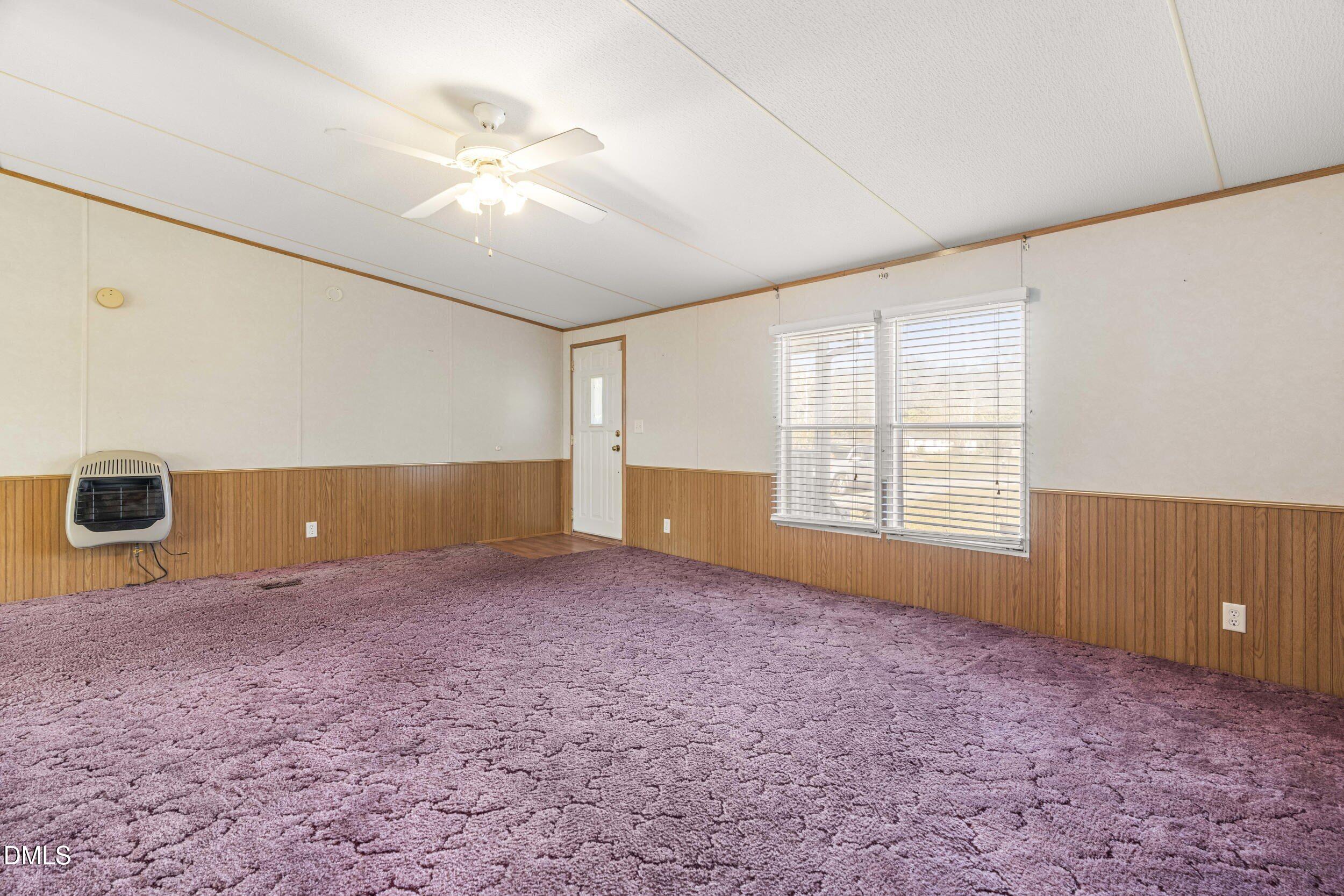 106 Roe Lane Clayton, NC 27527 - Photo 3 of 24 an empty room with windows and ceiling fan