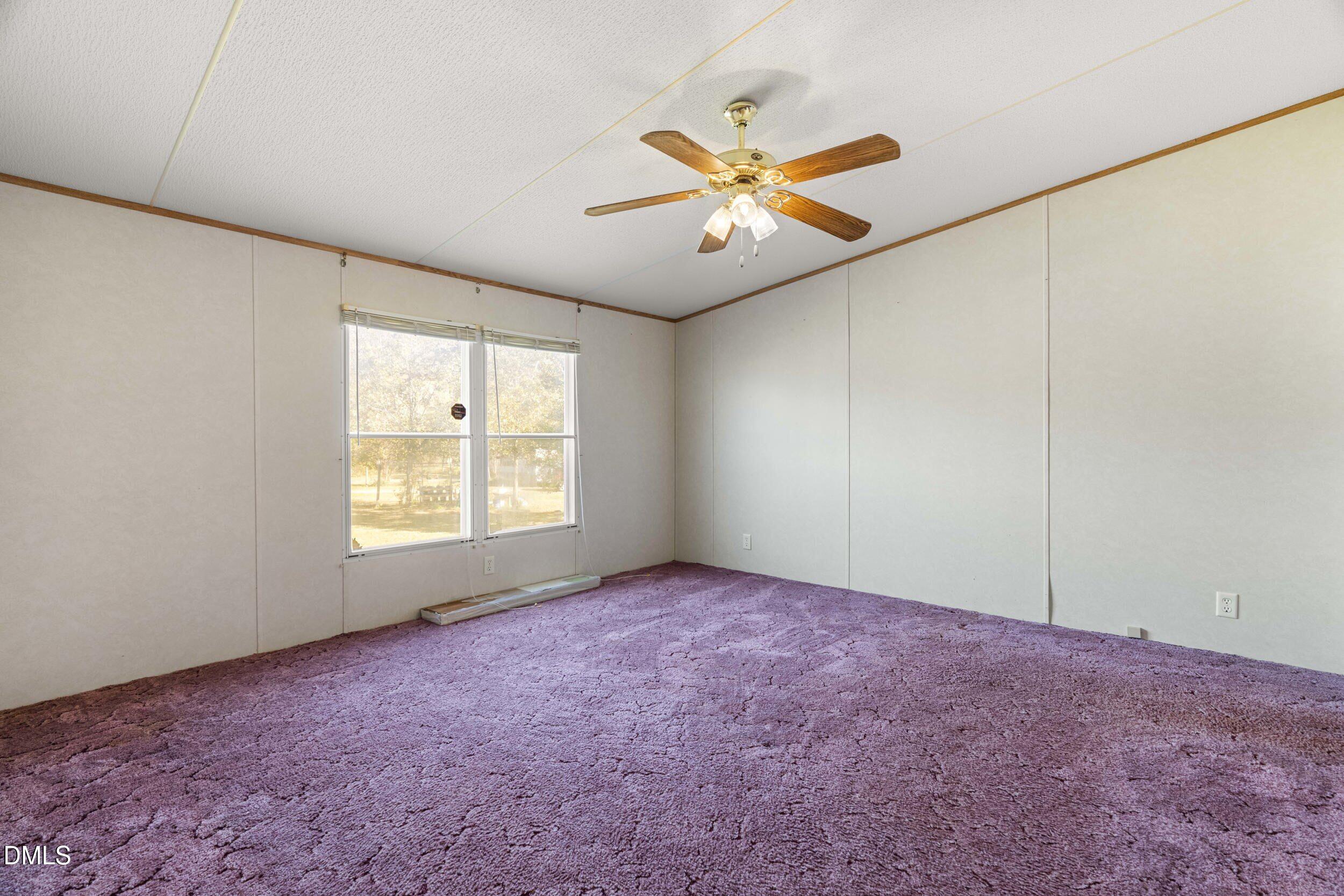 106 Roe Lane Clayton, NC 27527 - Photo 4 of 24 an empty room with windows and fan