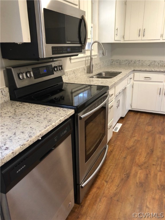 a kitchen with granite countertop a stove top oven microwave and cabinets